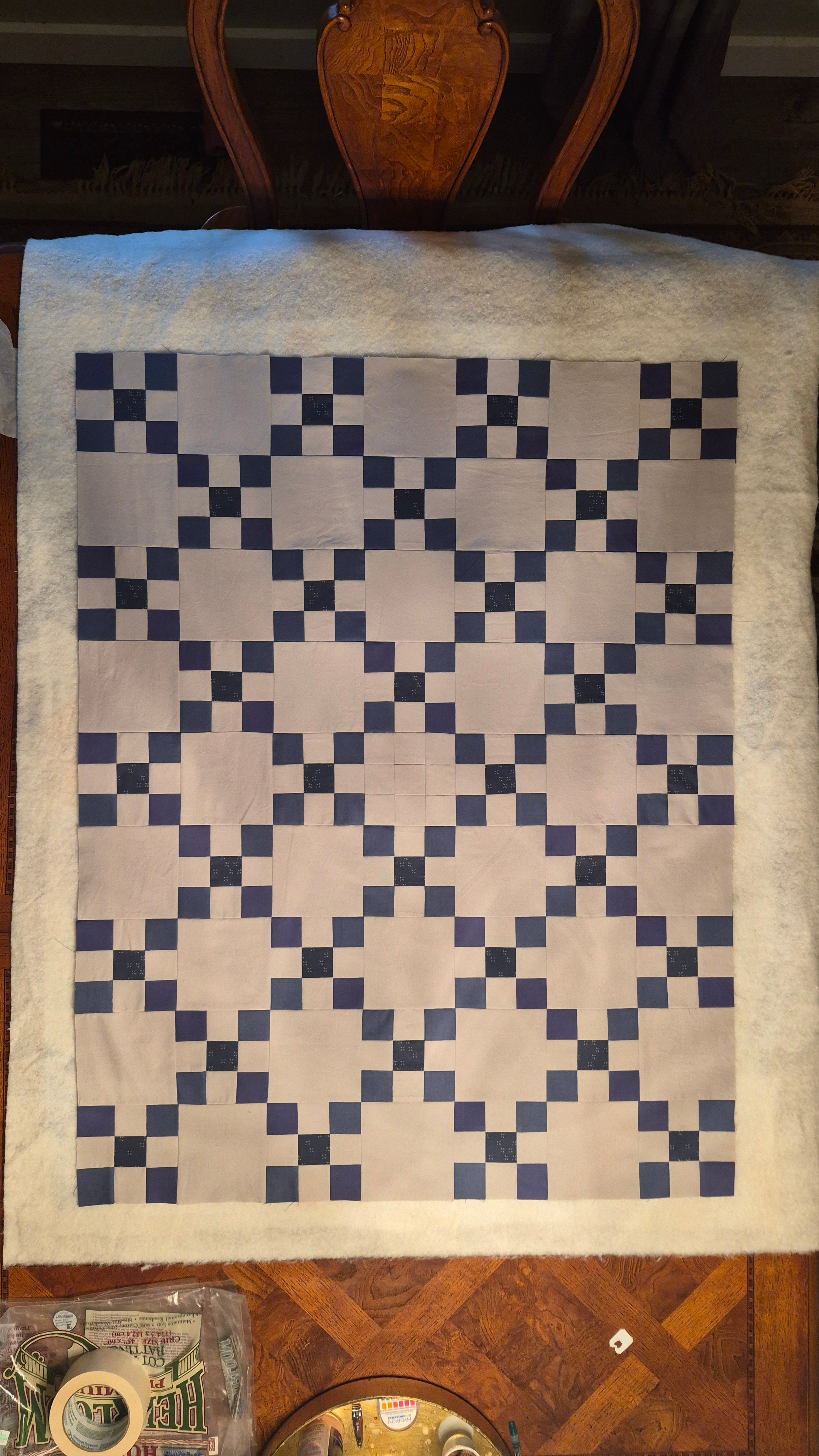 Quilt with blue and white diamond pattern on a wooden surface