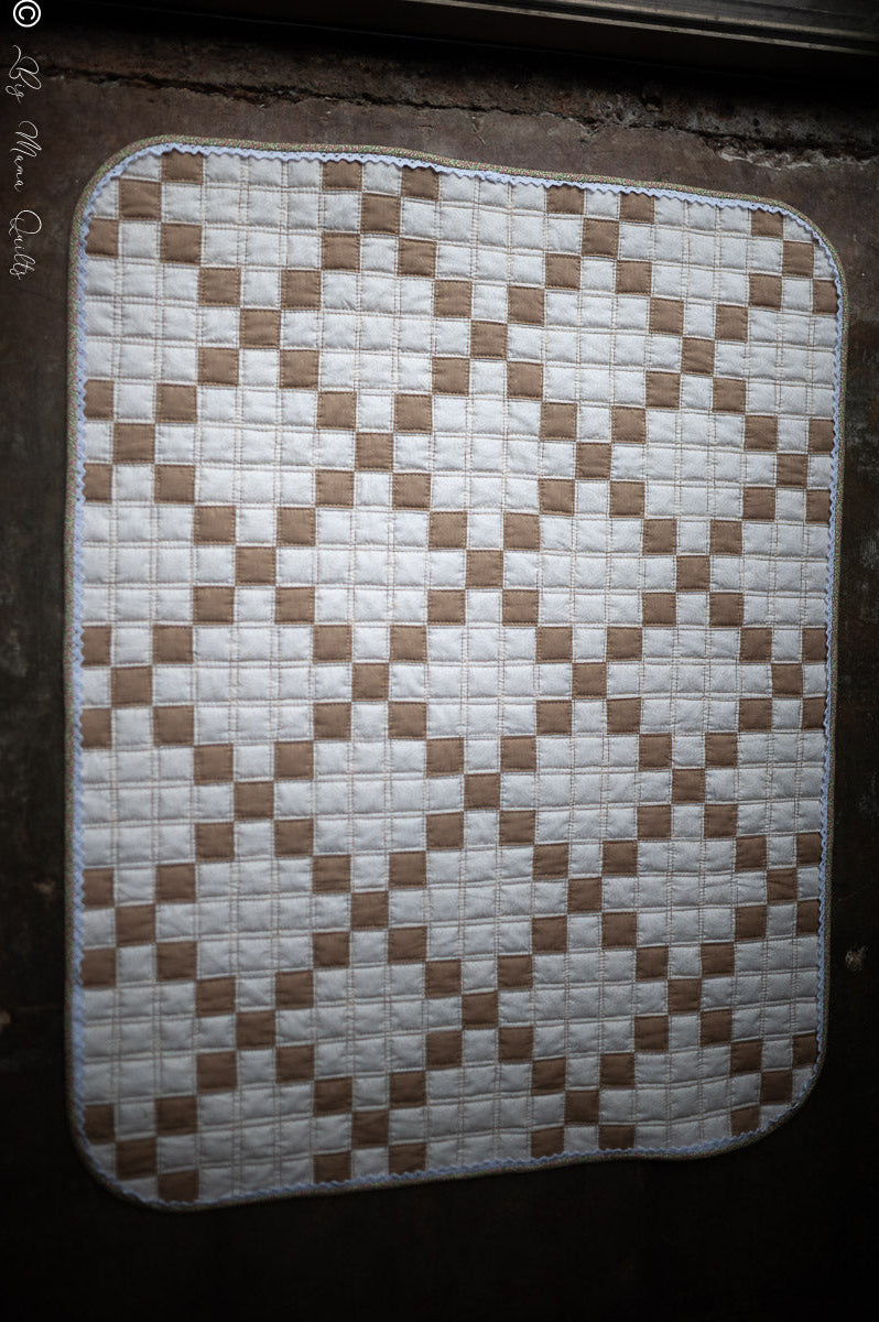 Traditional Irish Chain quilt with small brown squares on a light background.